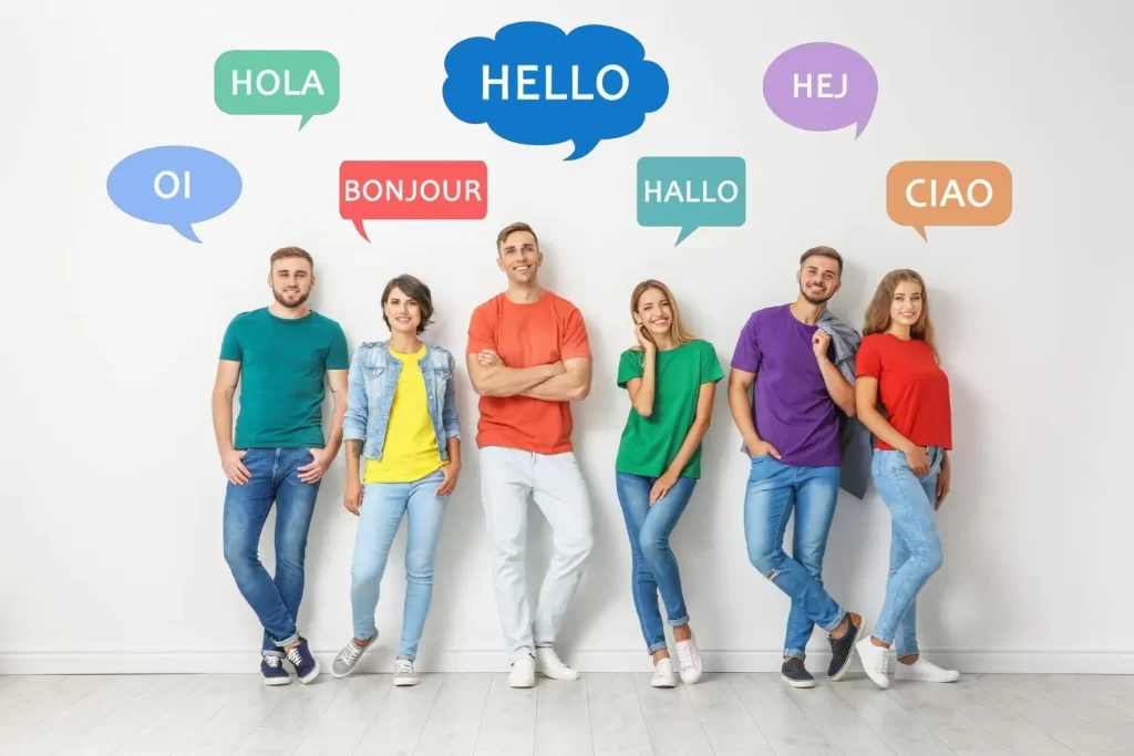 happy-people-posing-near-light-wall-illustration-speech-bubbles-with-word-hello-written-different-languages